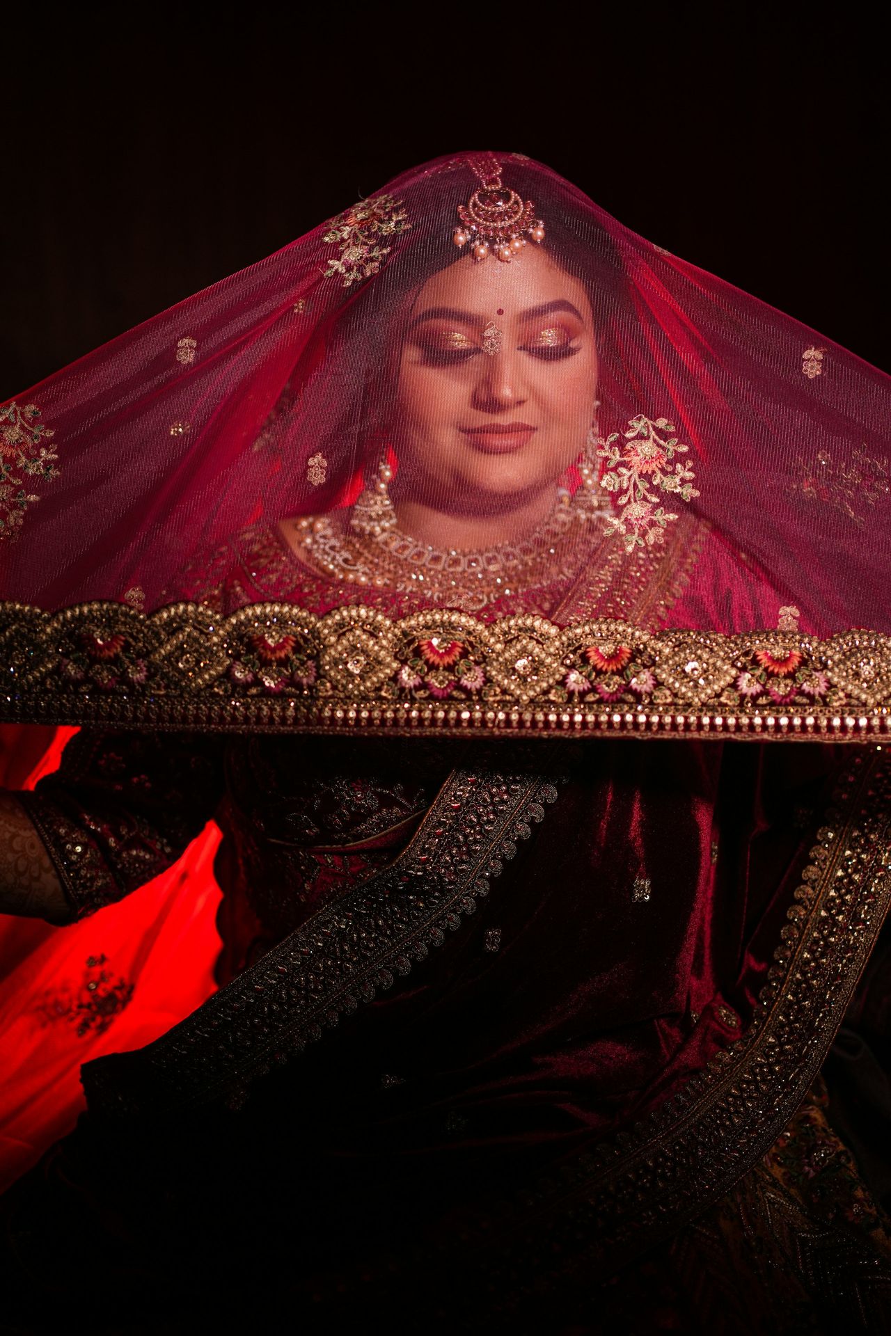 A woman dressed in a red bridal outfit